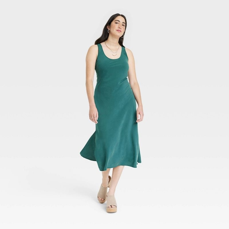 model in a teal midi slip tank dress with a round neck
