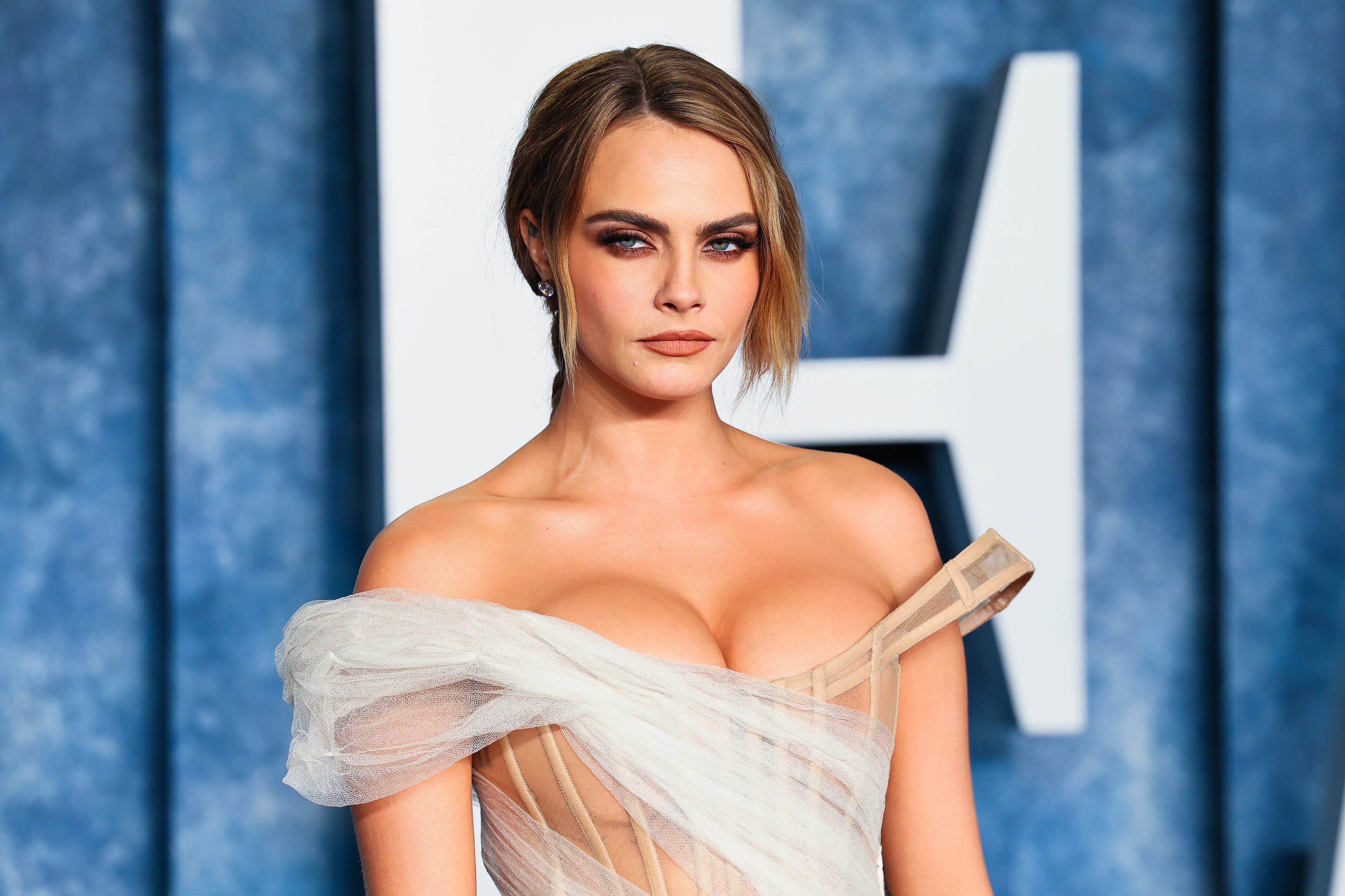 Closeup of Cara Delevingne in a sheer off the shoulder outfit