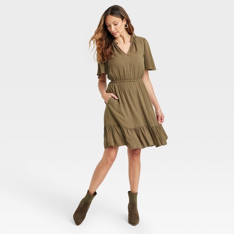 model in olive green flutter sleeve knee length dress