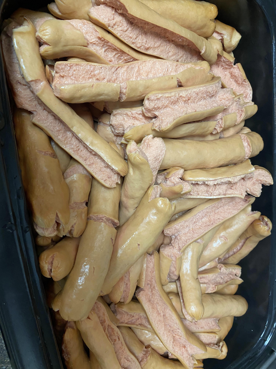 The hot dogs have split open, dried out, and become discolored