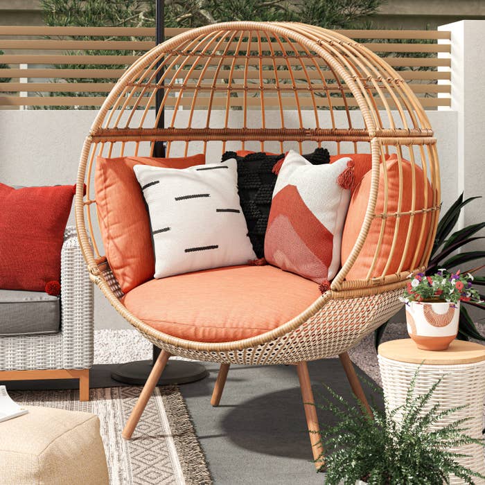 woven round egg chair with peach cushions