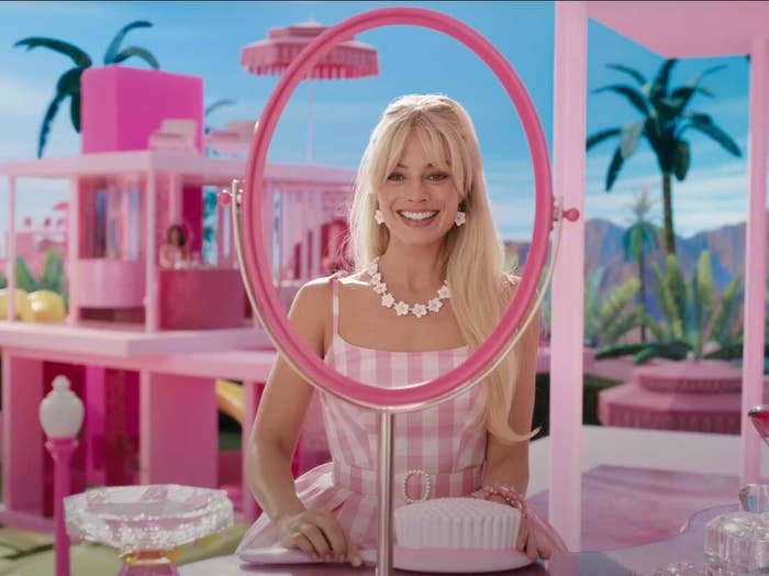 Barbie standing in front of a frame that&#x27;s supposed to be a mirror