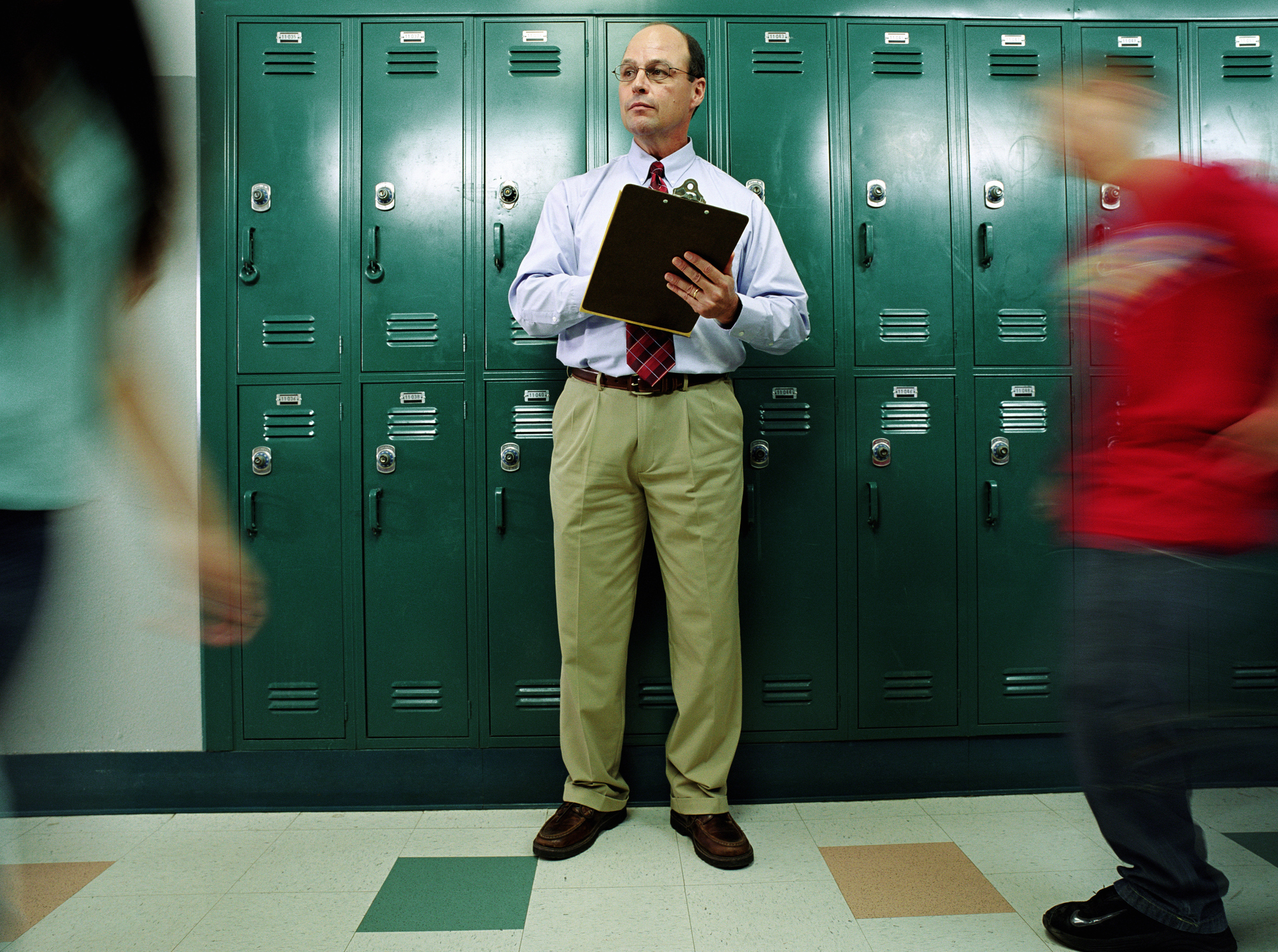 teacher in the hallway with a clipboard