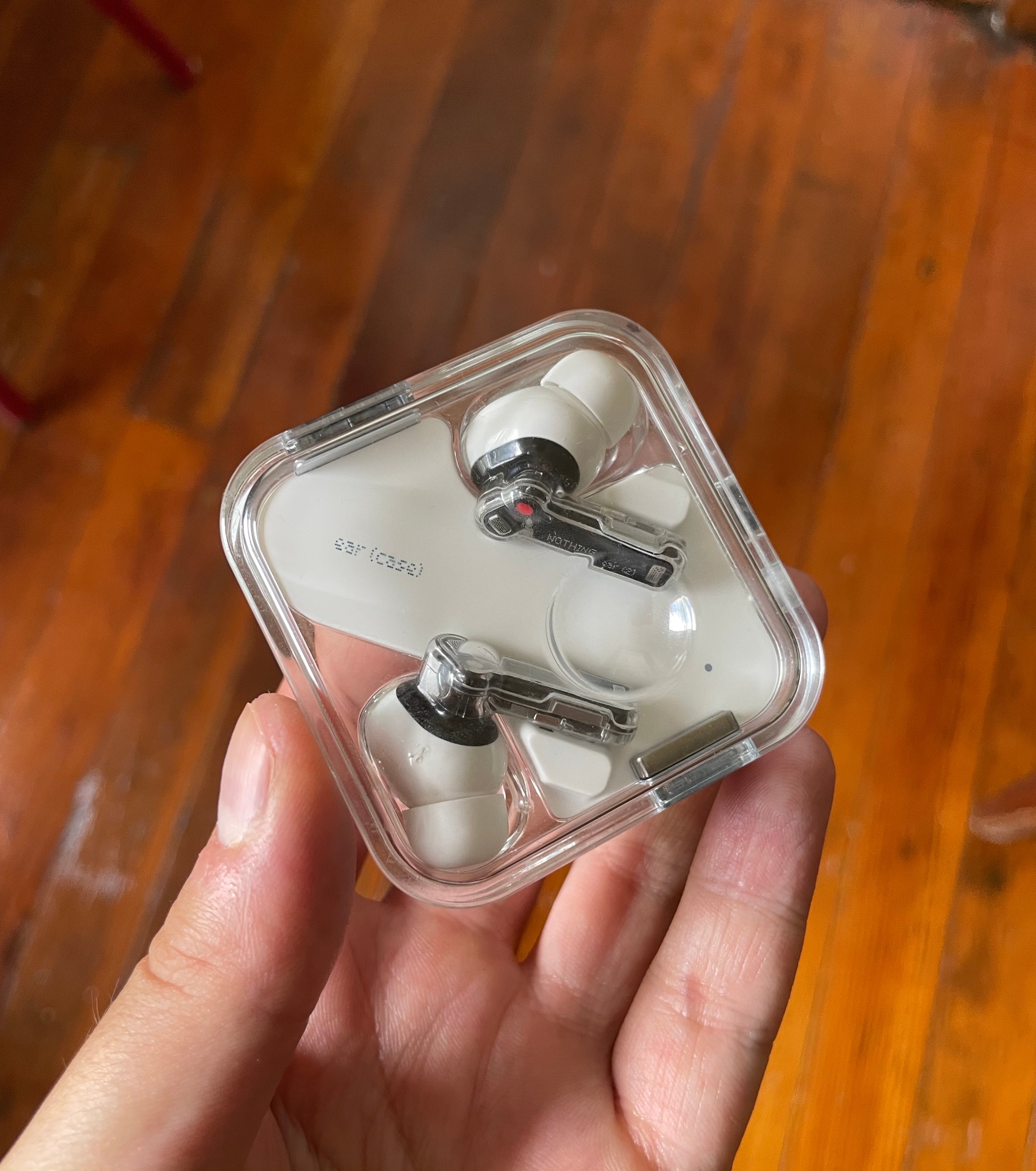 writer&#x27;s white headphones in their clear charging case