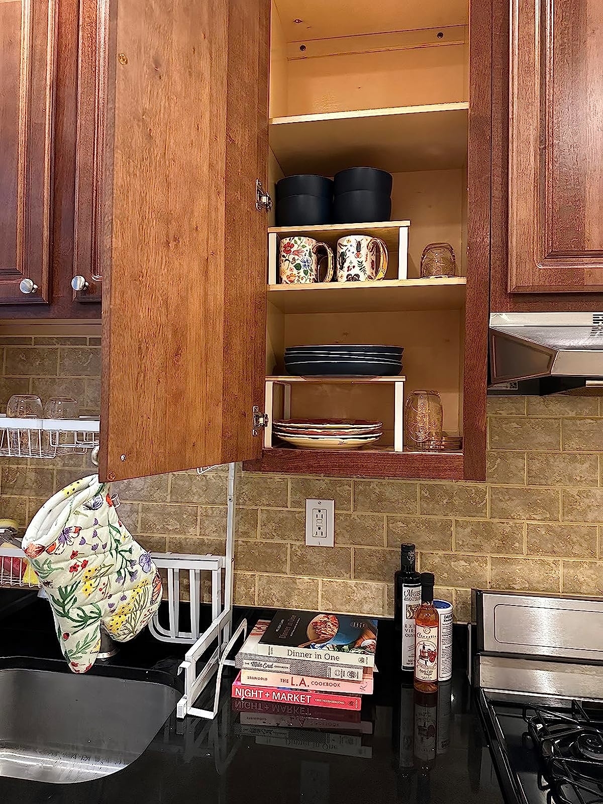 Reviewer image of the shelf organizers inside their kitchen cabinet