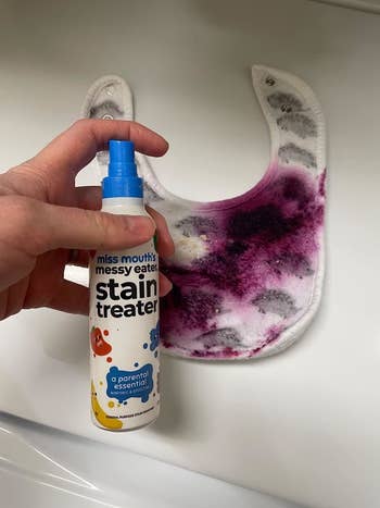 Reviewer image of a bib stained with berries next to bottle of stain remover