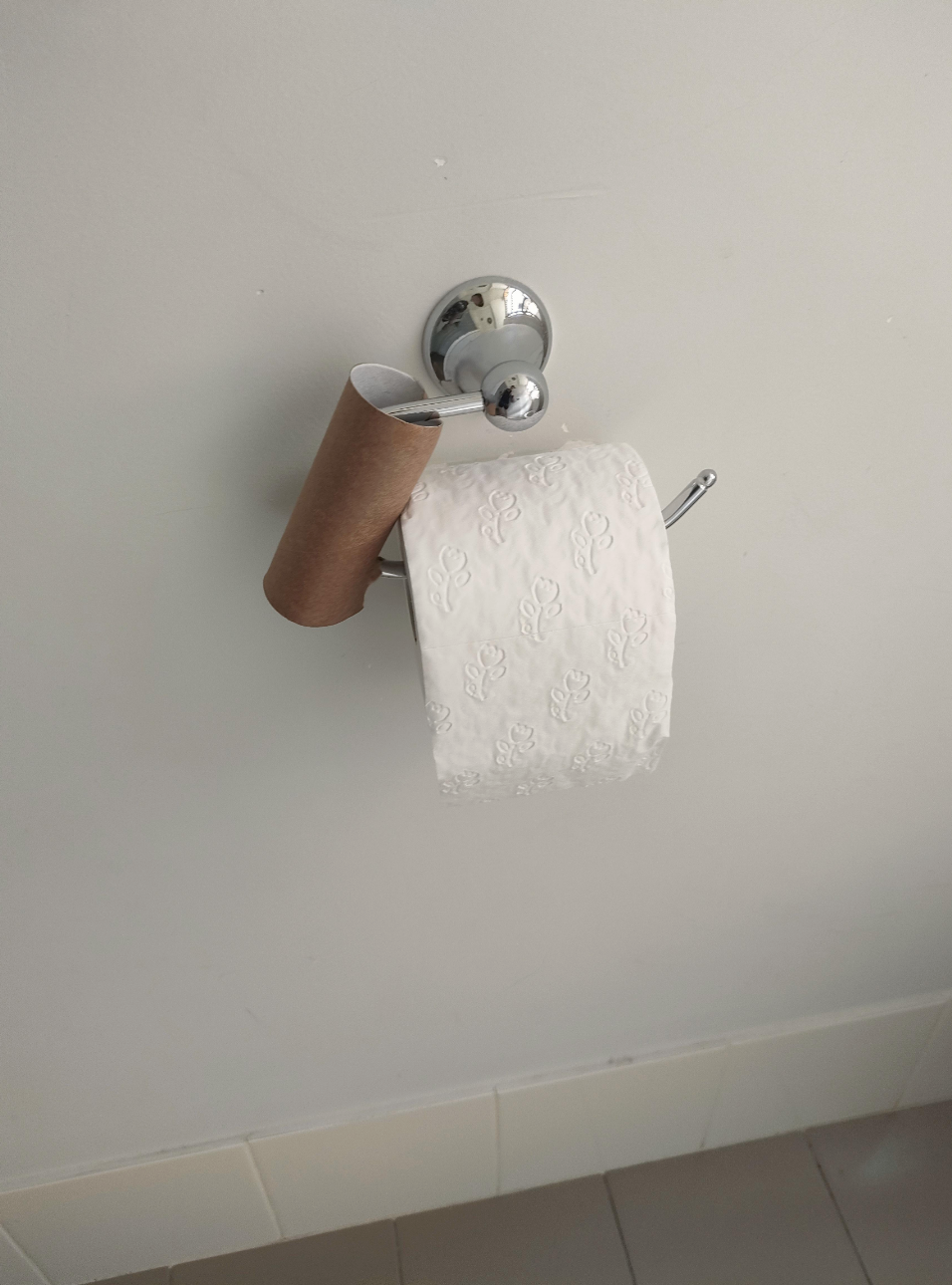 An empty toilet paper roll next to a full one