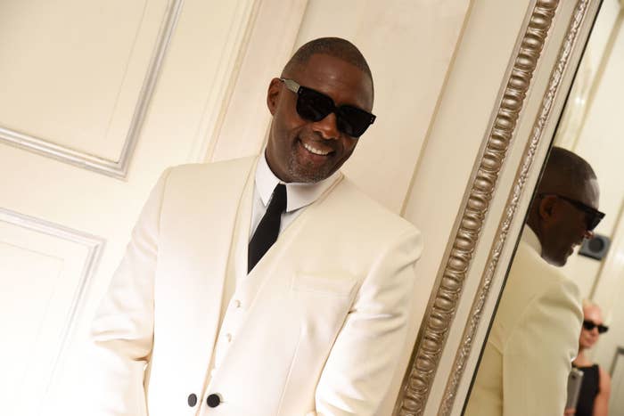 Closeup of Idris Elba in a suit and tie and sunglasses