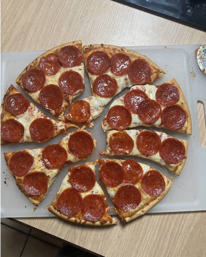 Pizza pie sliced randomly to avoid any cut pepperoni