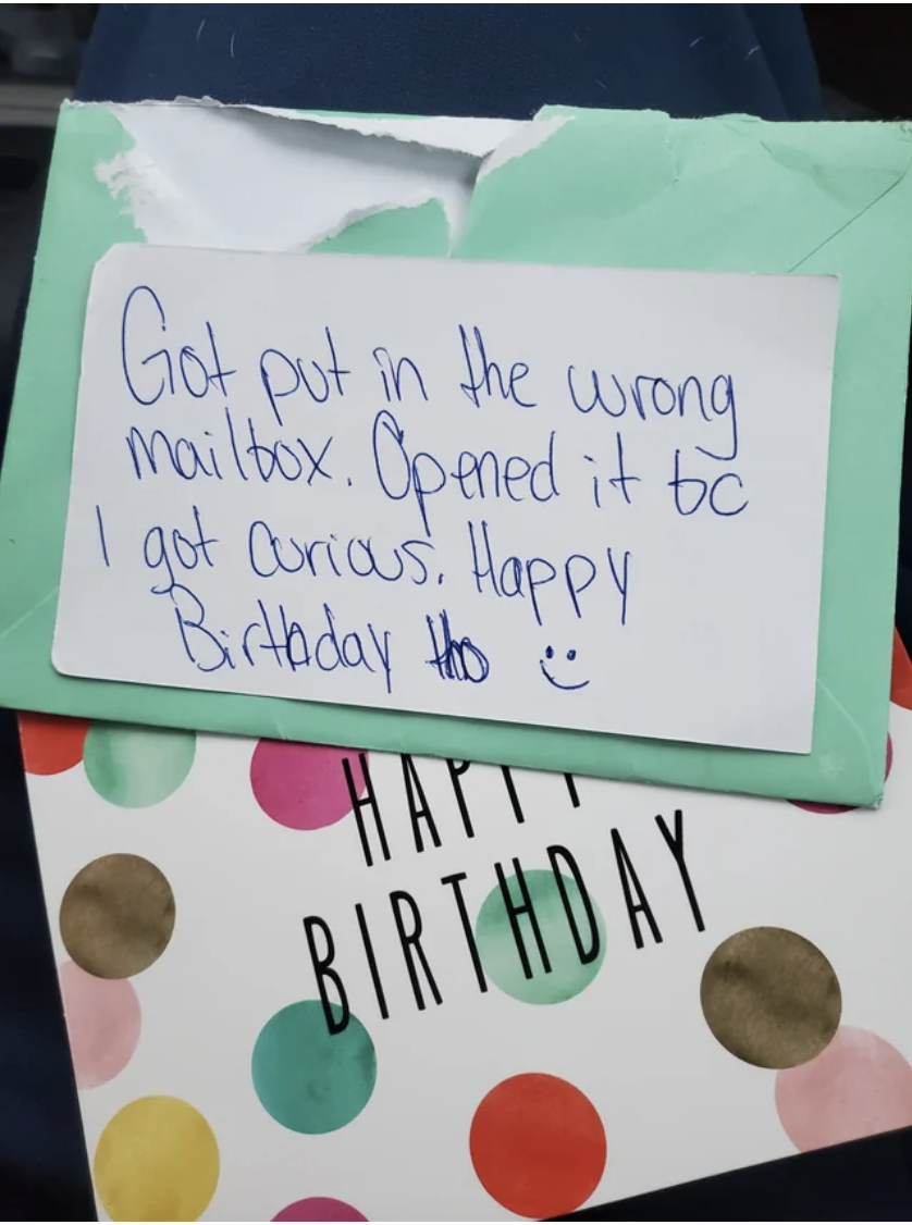 Neighbor&#x27;s handwritten note covering an open birthday card: &quot;Got put in the wrong mailbox; opened it bc I got curious; happy birthday tho&quot; with a smiley face