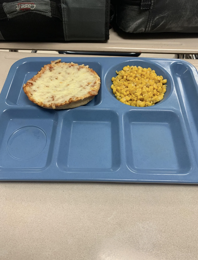 A tray with a mini pizza and corn