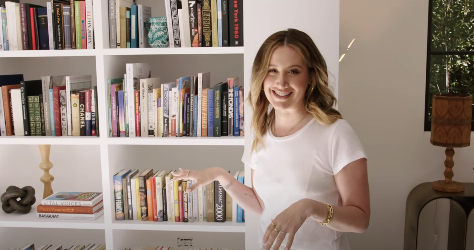 Ashley Tisdale standing next to her bookshelf