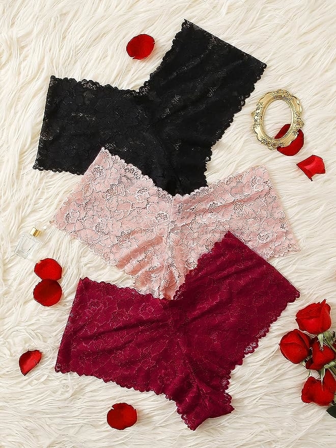 three pairs of the underwear in black, pink, and red