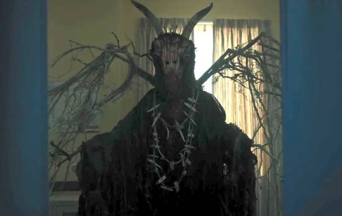 The gargoyle king stands in a hospital room. It appears to be a cloaked figure, with wings made of twigs, and the head of an animal.