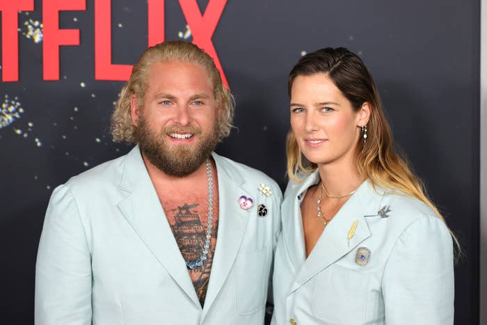 Close-up of Jonah and Sarah at a press event in matching suits