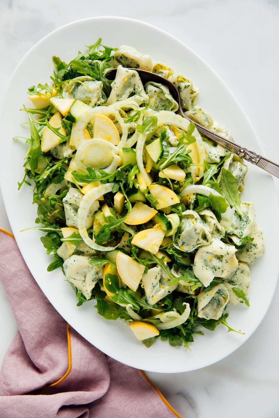 Plated tortellini salad topped with summer squash and fennel