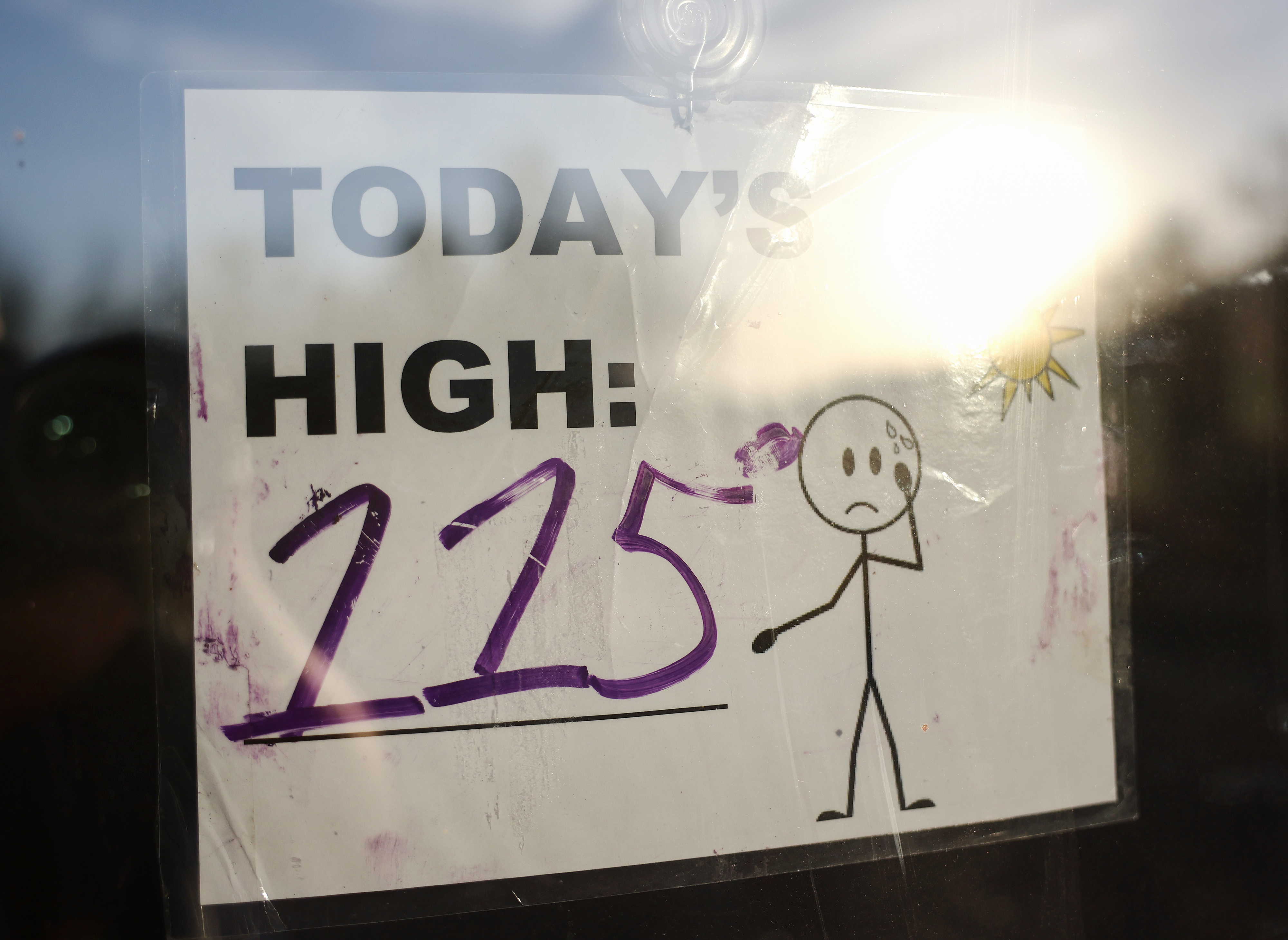 A sign in a window that says &quot;Today&#x27;s high: 115&quot;