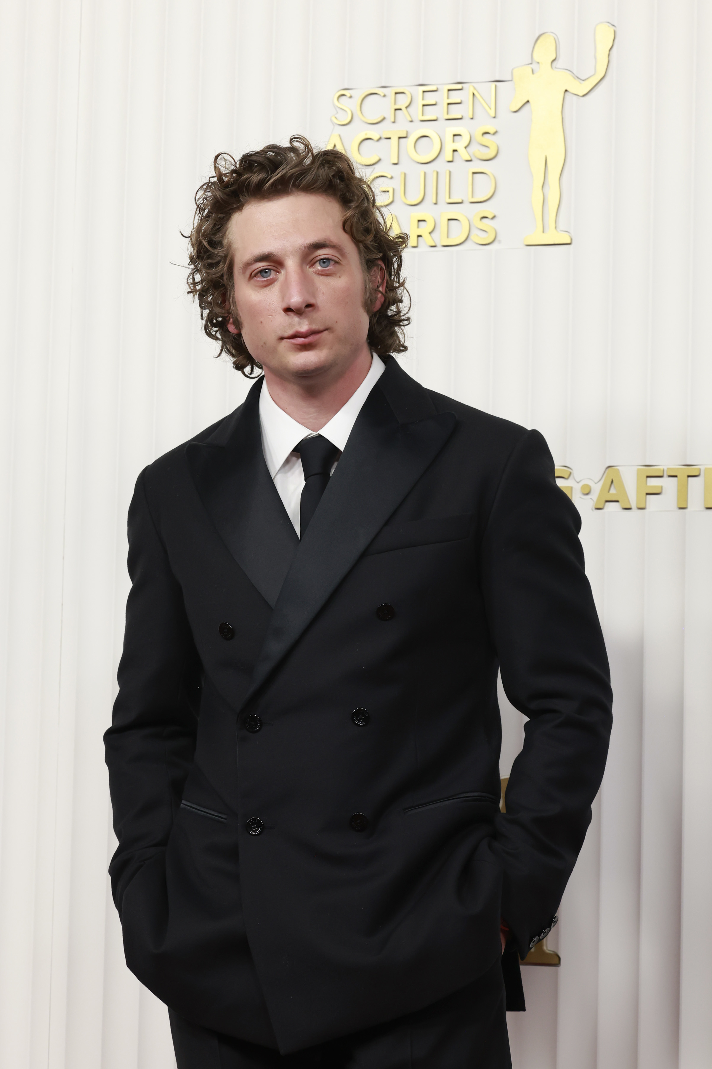 A closeup of jeremy allen white in a suit on the red carpet of an awards show