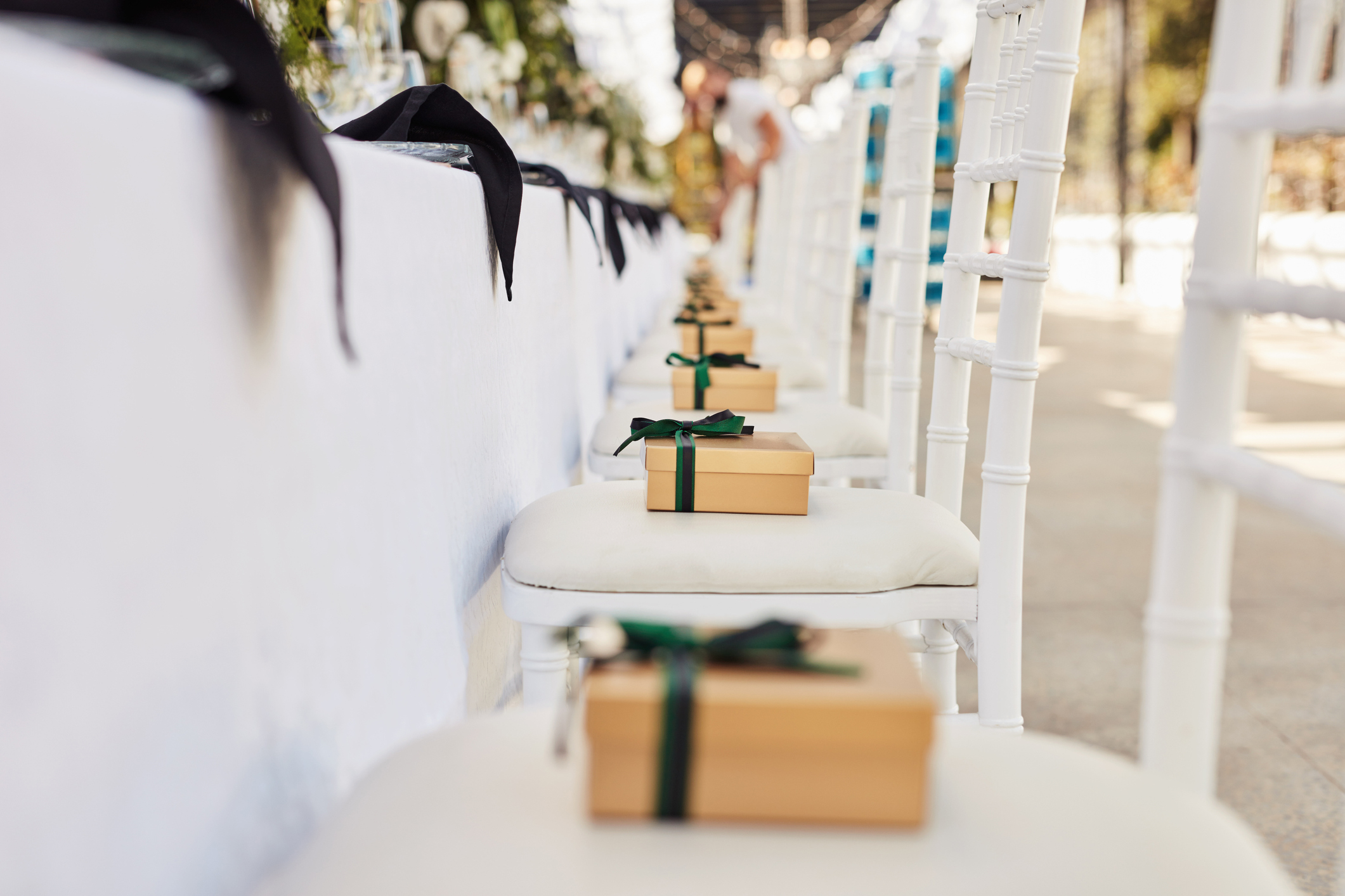 Party favors (little gift boxes with bows) on chairs