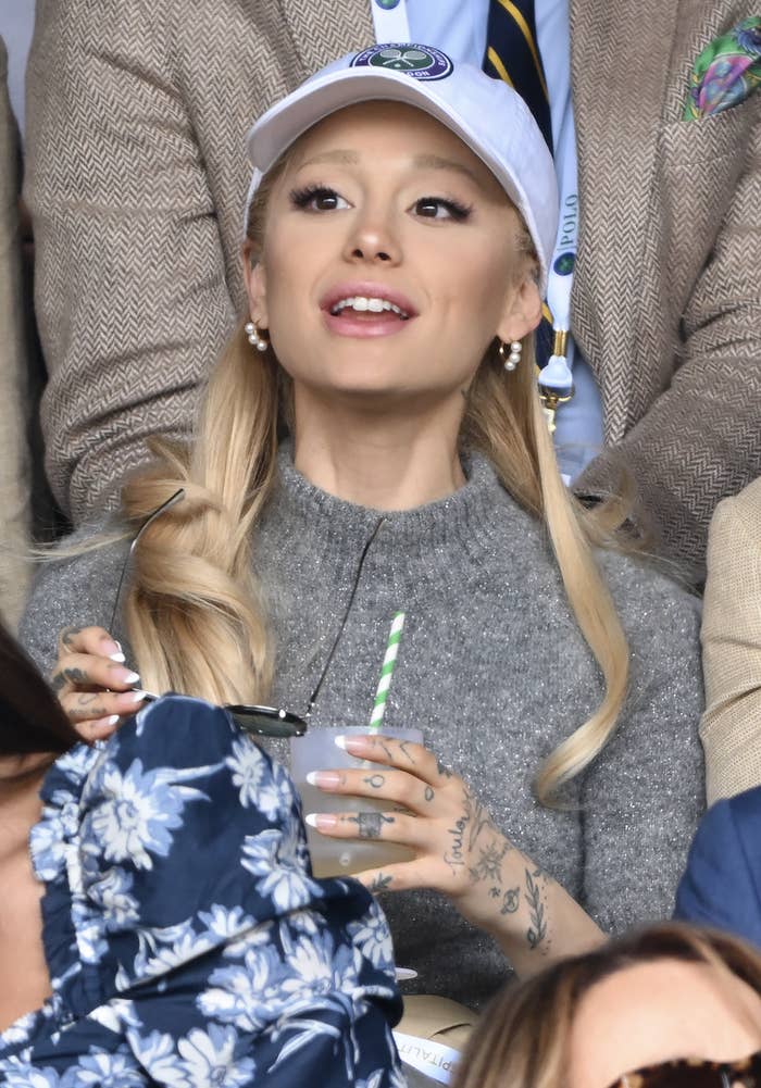 Closeup of Ariana Grande holding a cup at a sports event