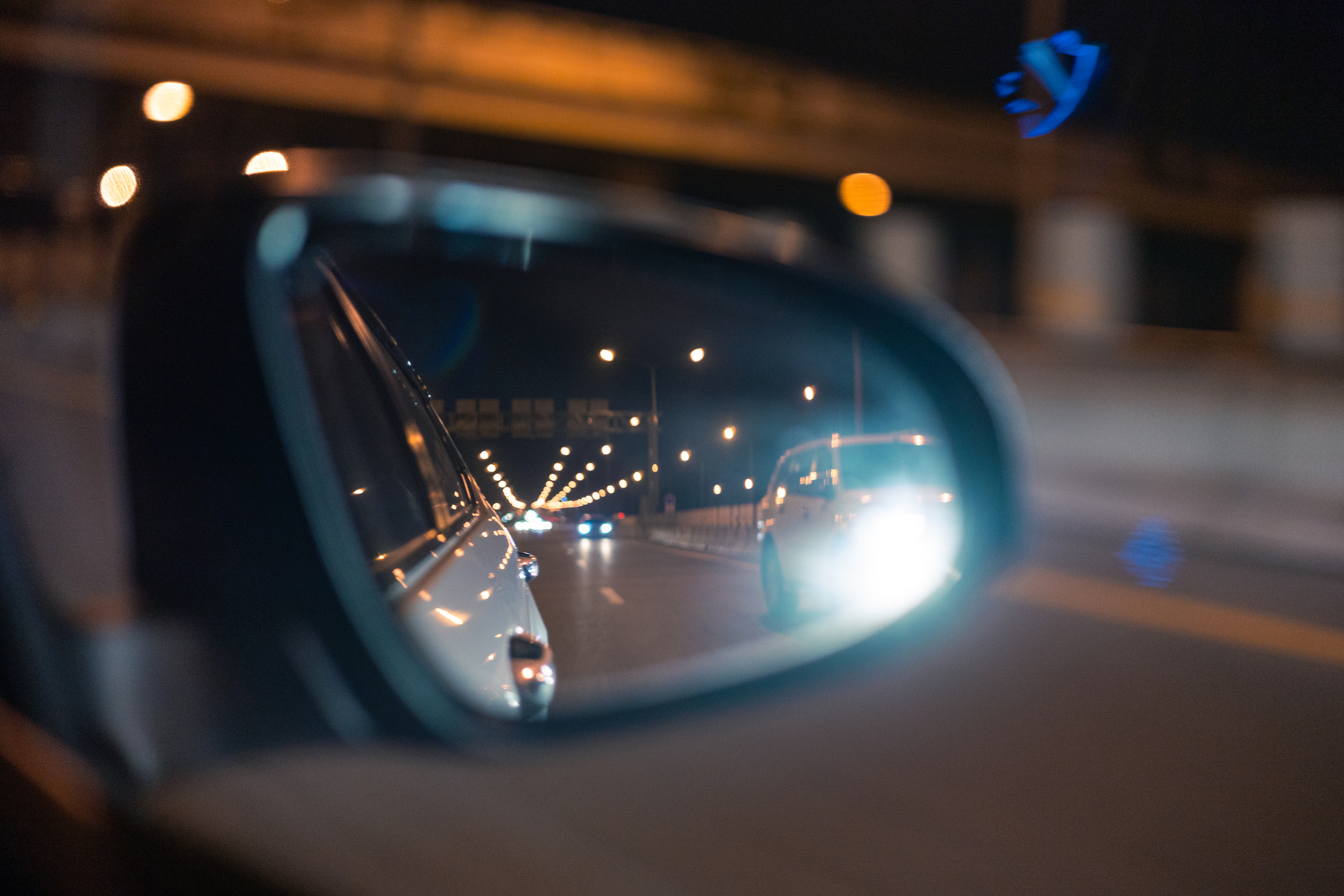side-view mirror on car reflecting a highway