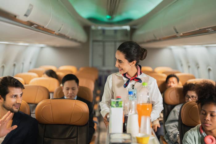 Flight attendant serving drinks on a plane
