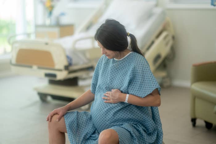 A pregnant woman in a hospital wearing a hospital gown