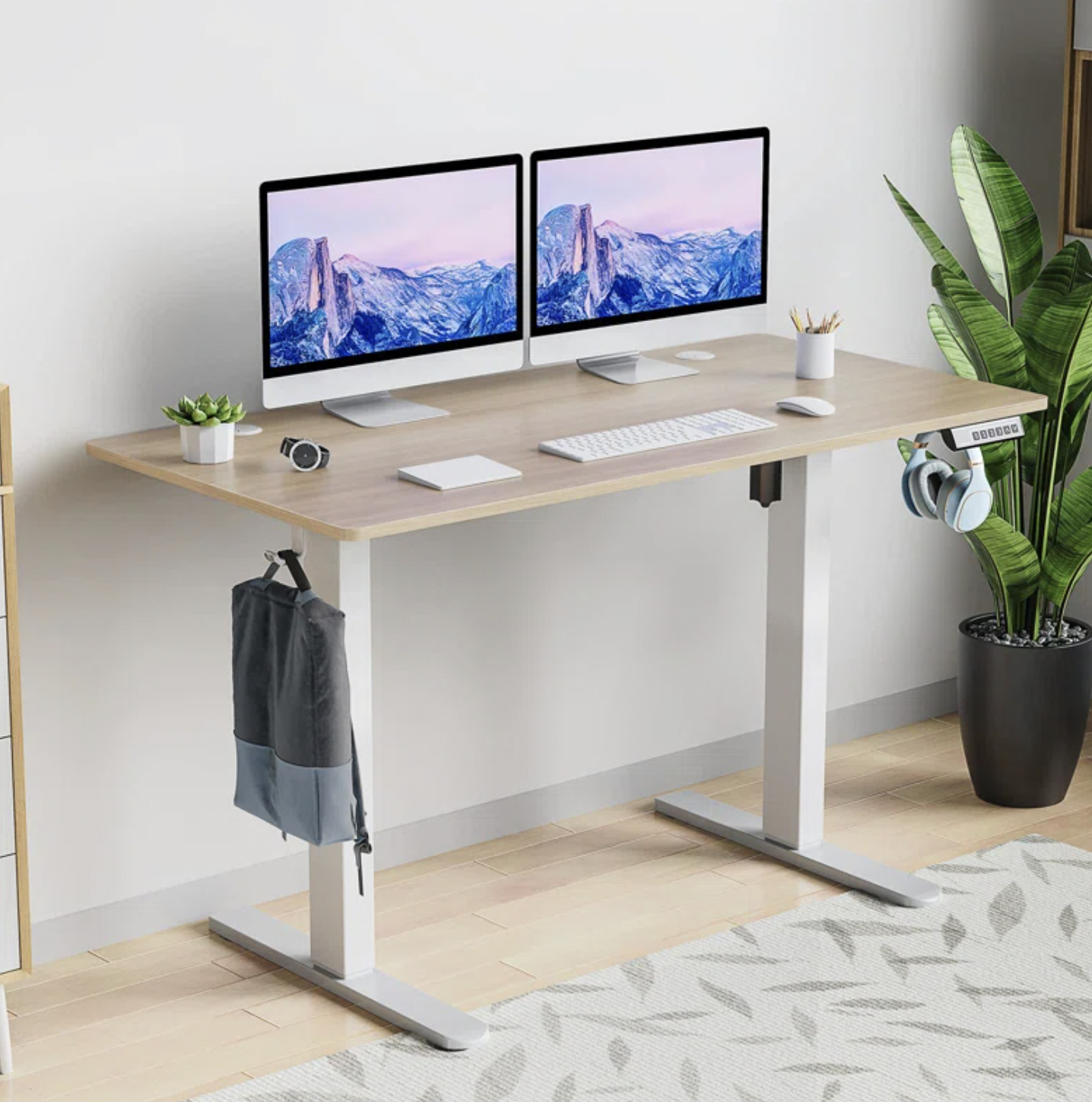 The beige desk with two monitors on it in middle height position