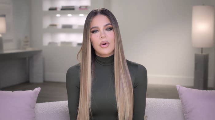 Close-up of Khloé sitting on a couch