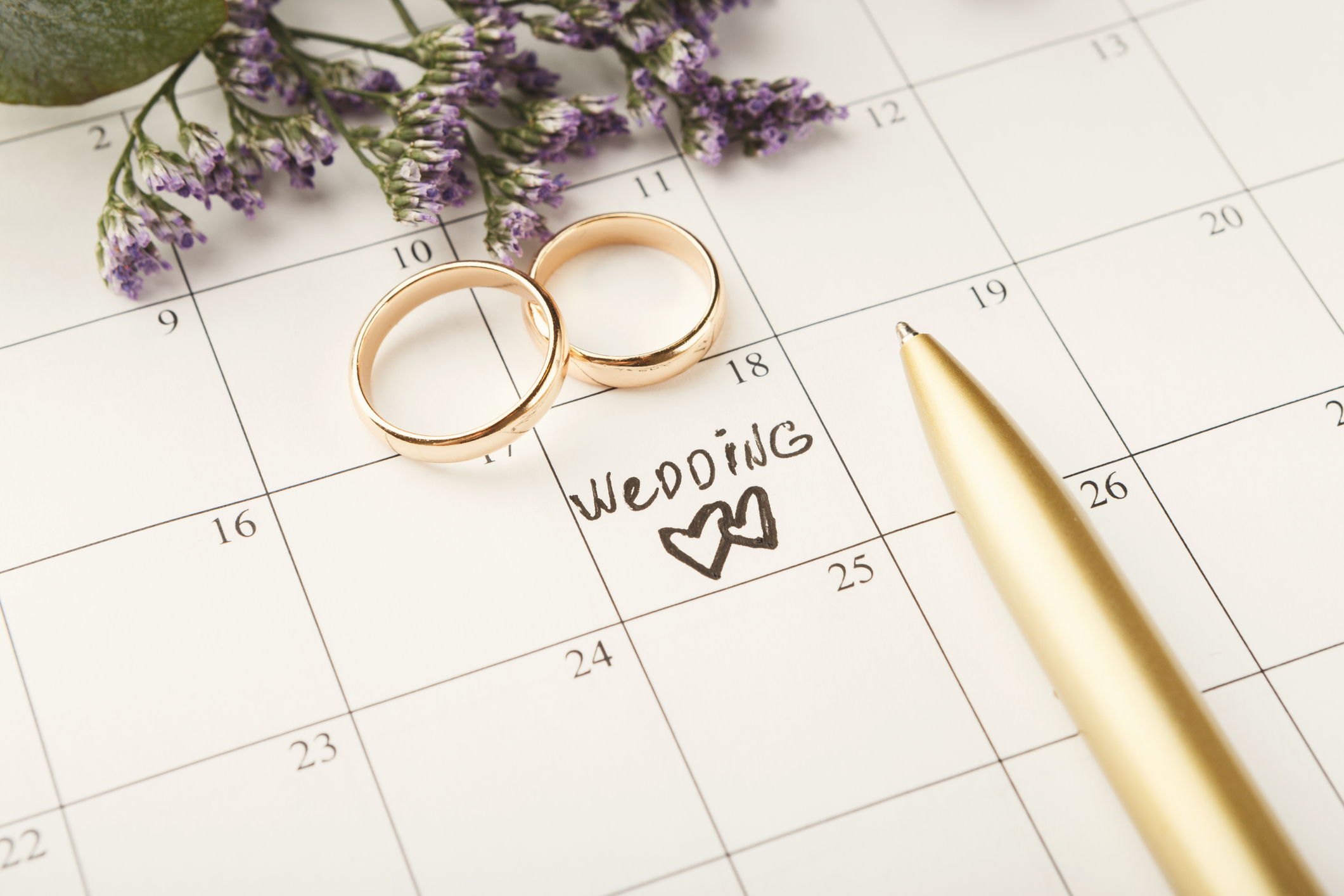 Wedding rings on a calendar with a wedding date penciled in
