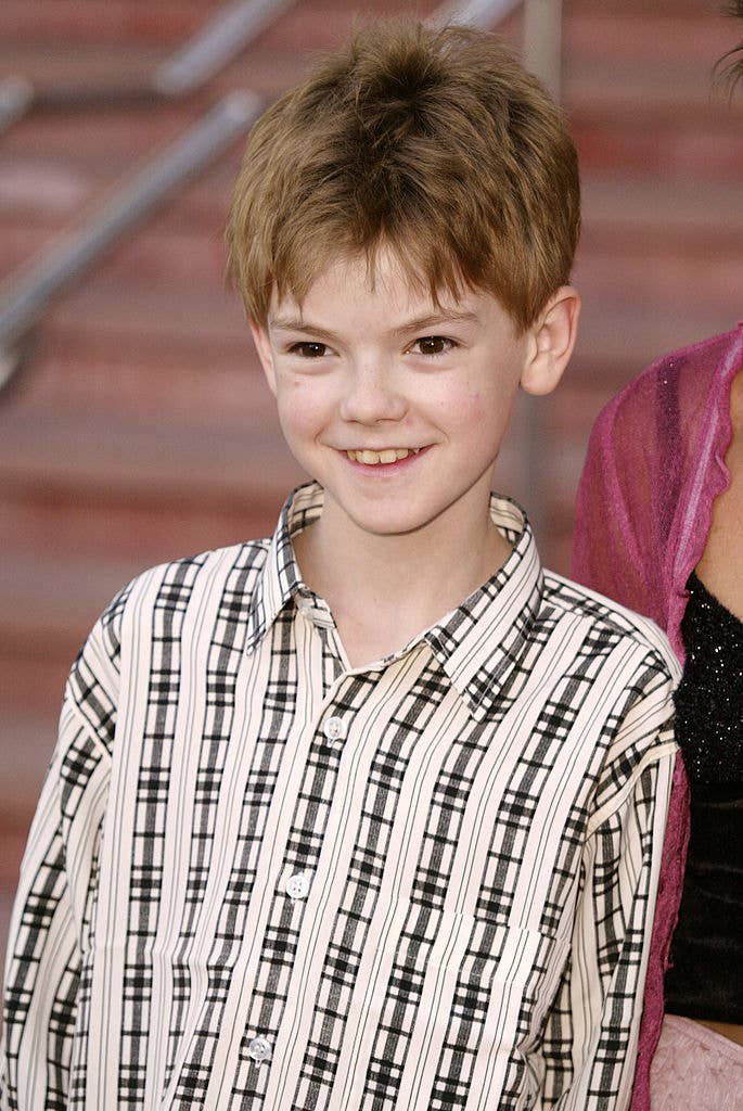 Thomas Brodie-Sangster as a kid smiling at a media event