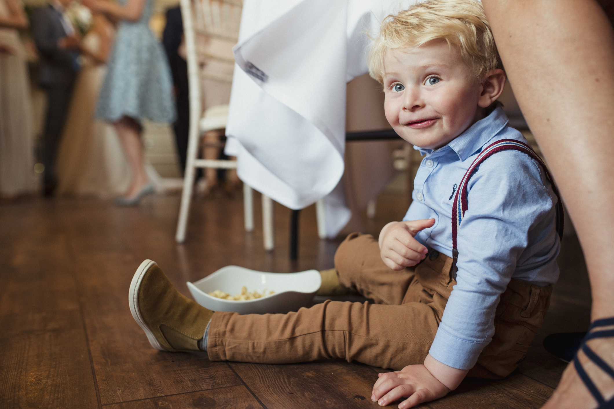 A toddler sitting on the floor and smiling