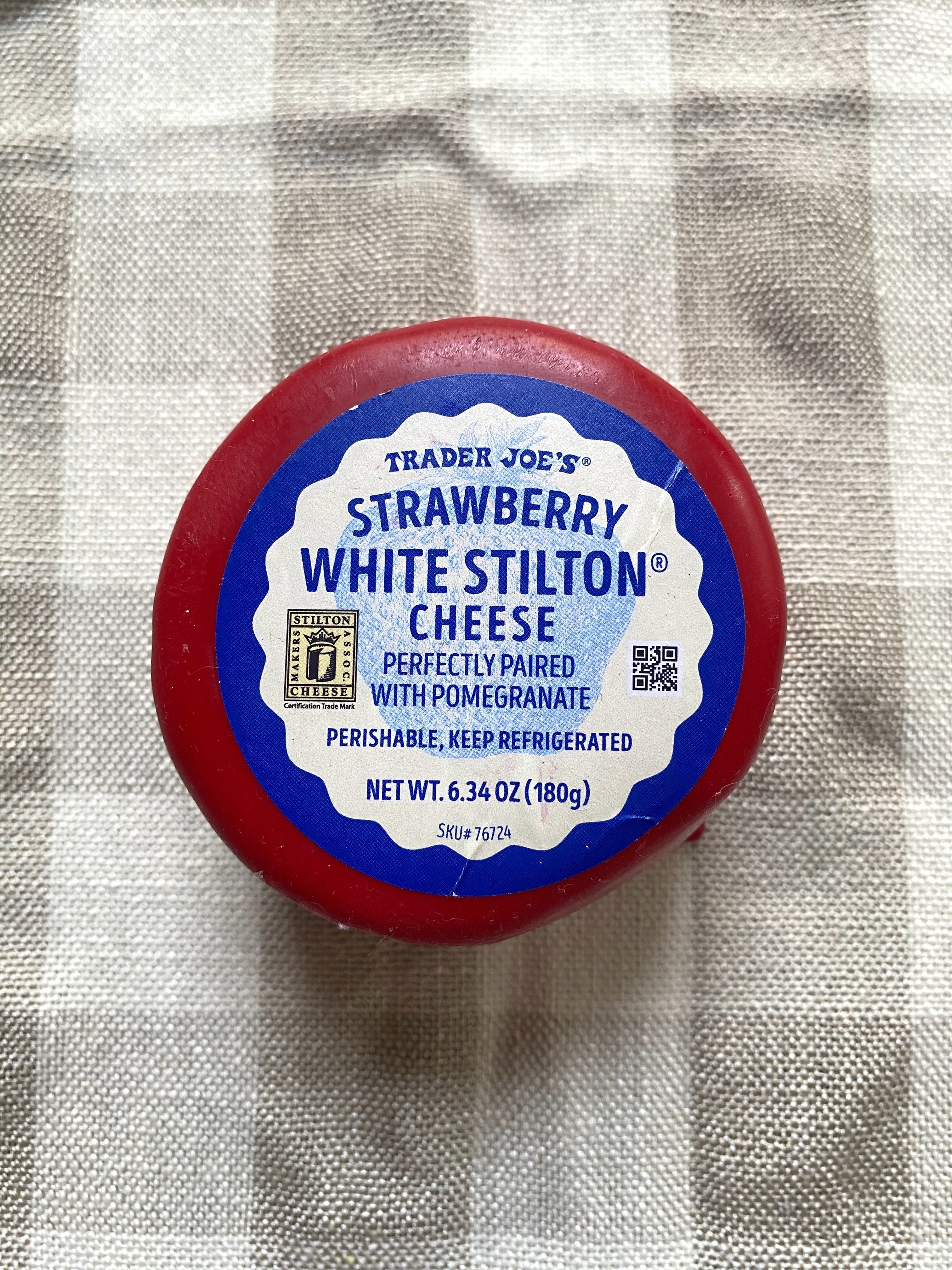A wheel of strawberry stilton cheese with a red wax coating