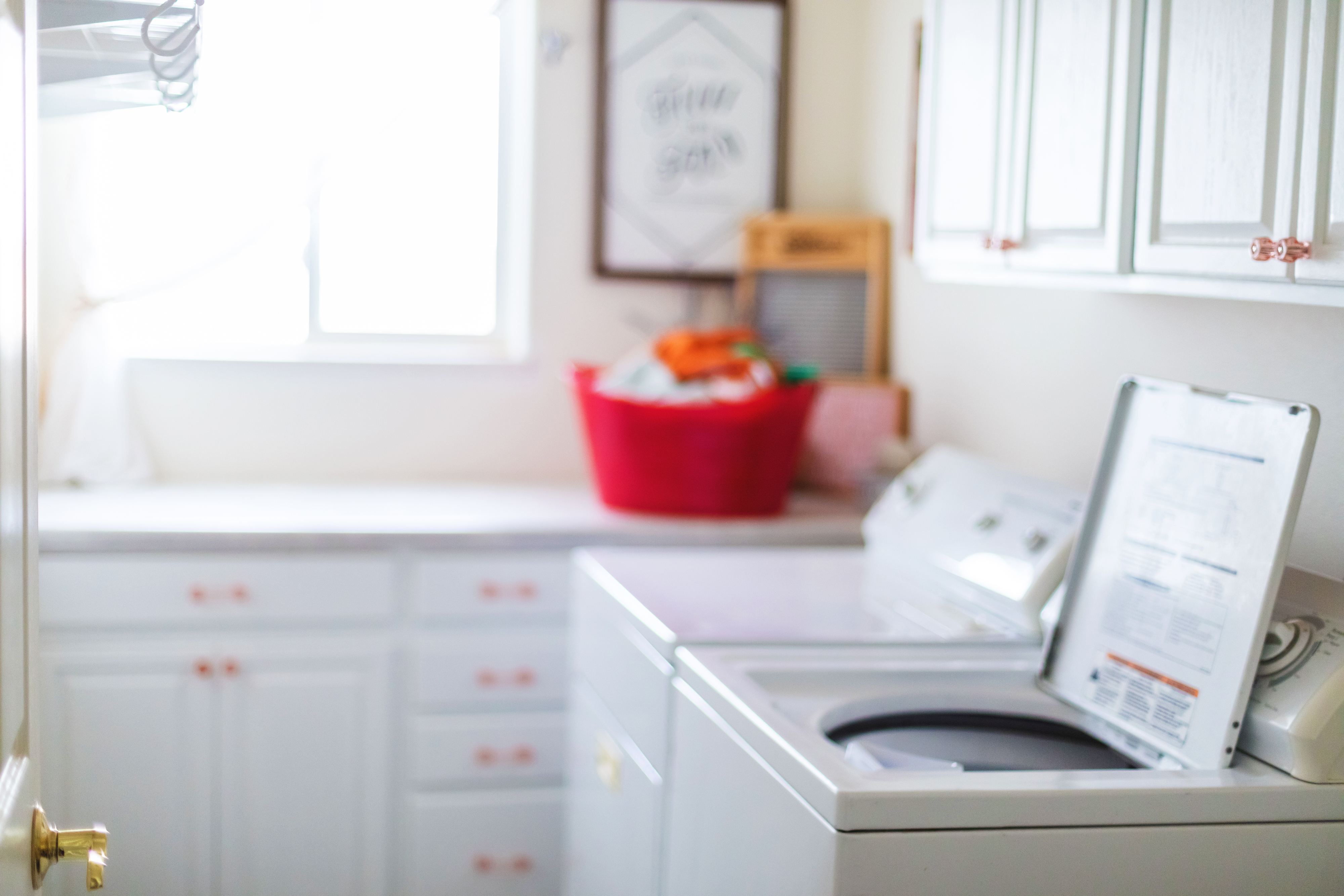 View of a laundry room with white furnishings