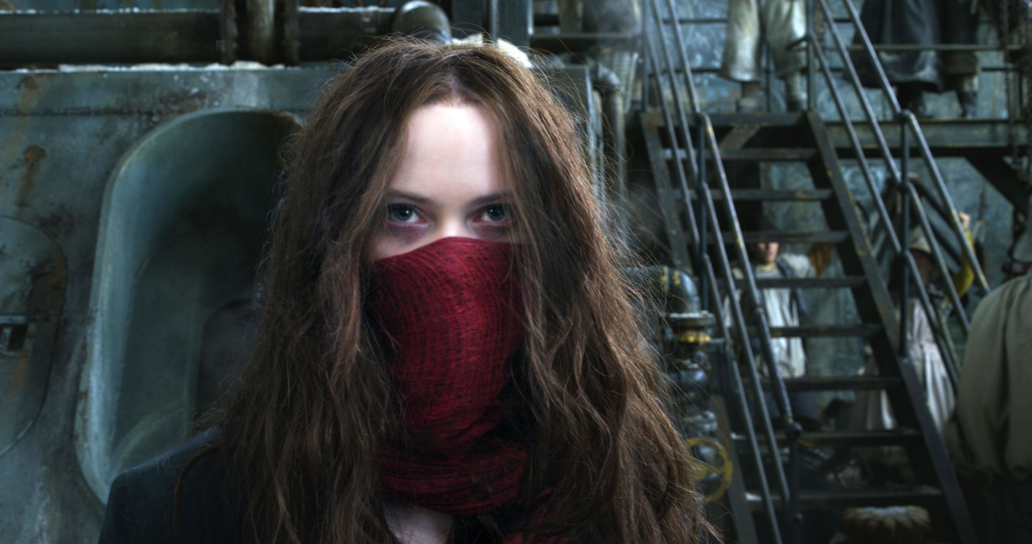 A woman in a red mask stares angrily near an industrial staircase