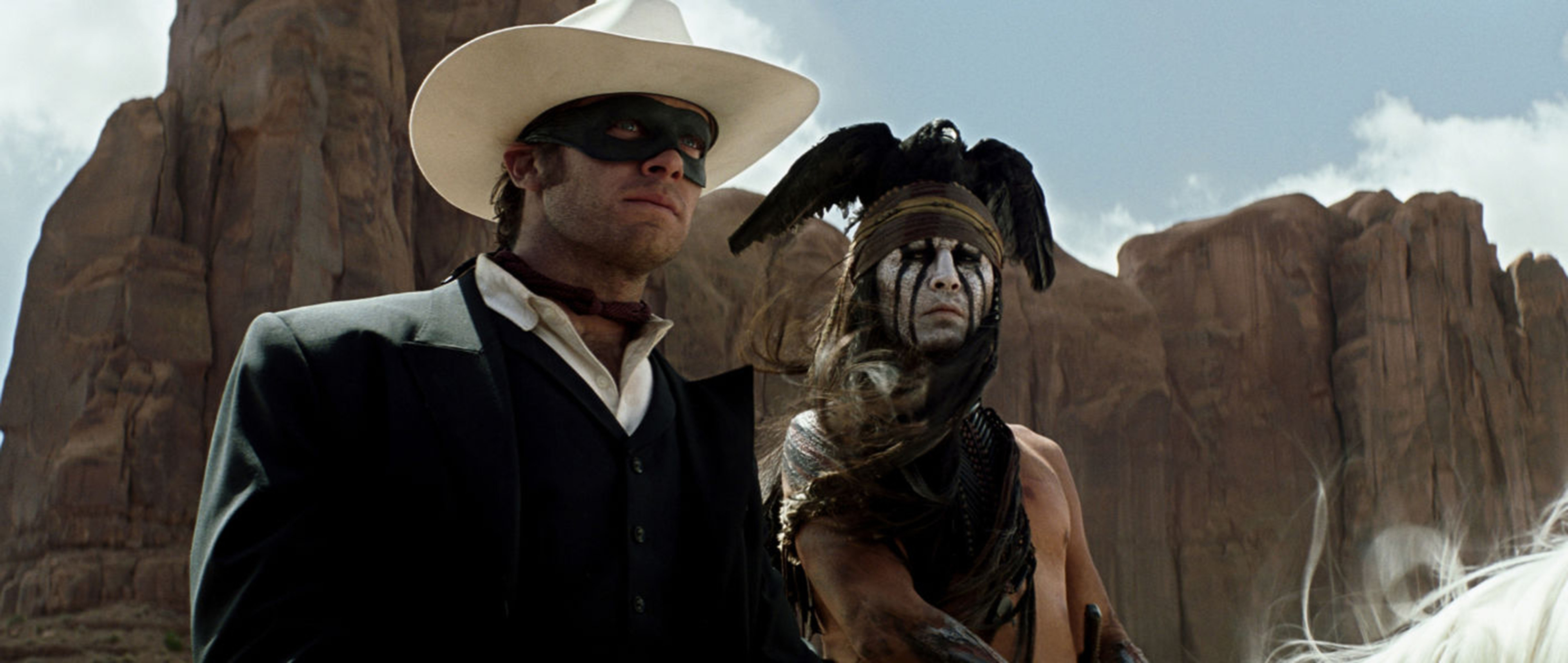 Armie Hammer and Johnny Depp stand by a mountain pattern in the desert sun
