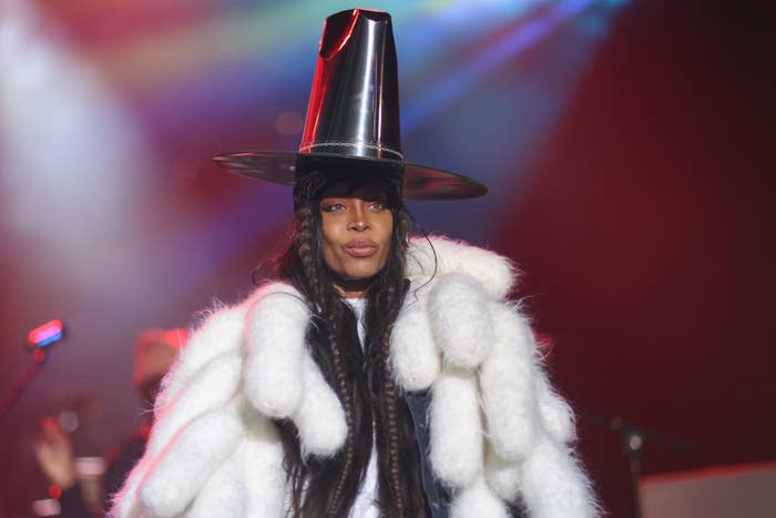 closeup of her on stage wearing a fuzzy jacket and tall top hat