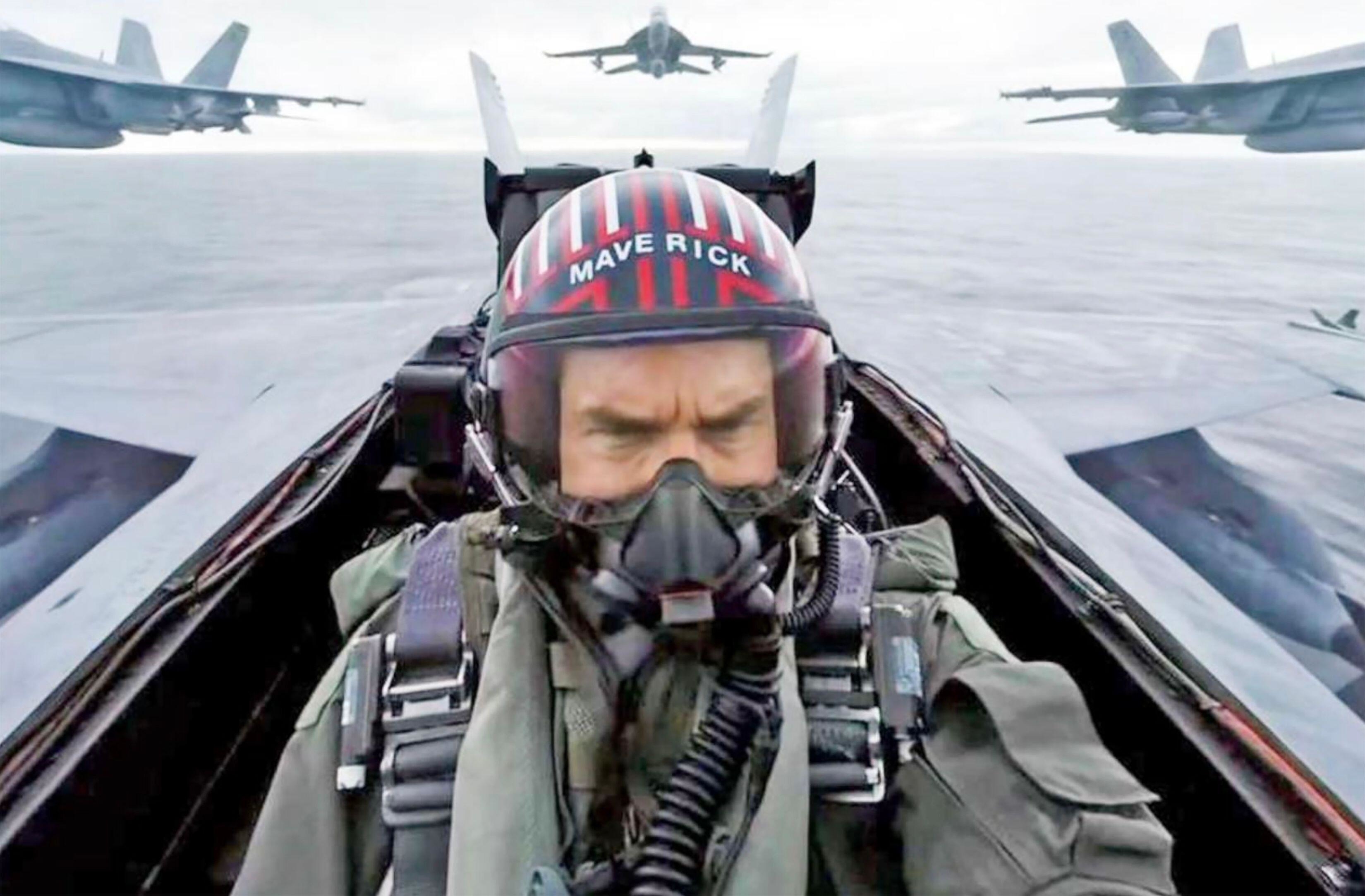 Tom Cruise soars above the ocean in a jet plane near a number of additional aircraft