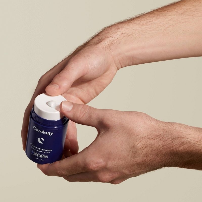 A person squeezing out face cream