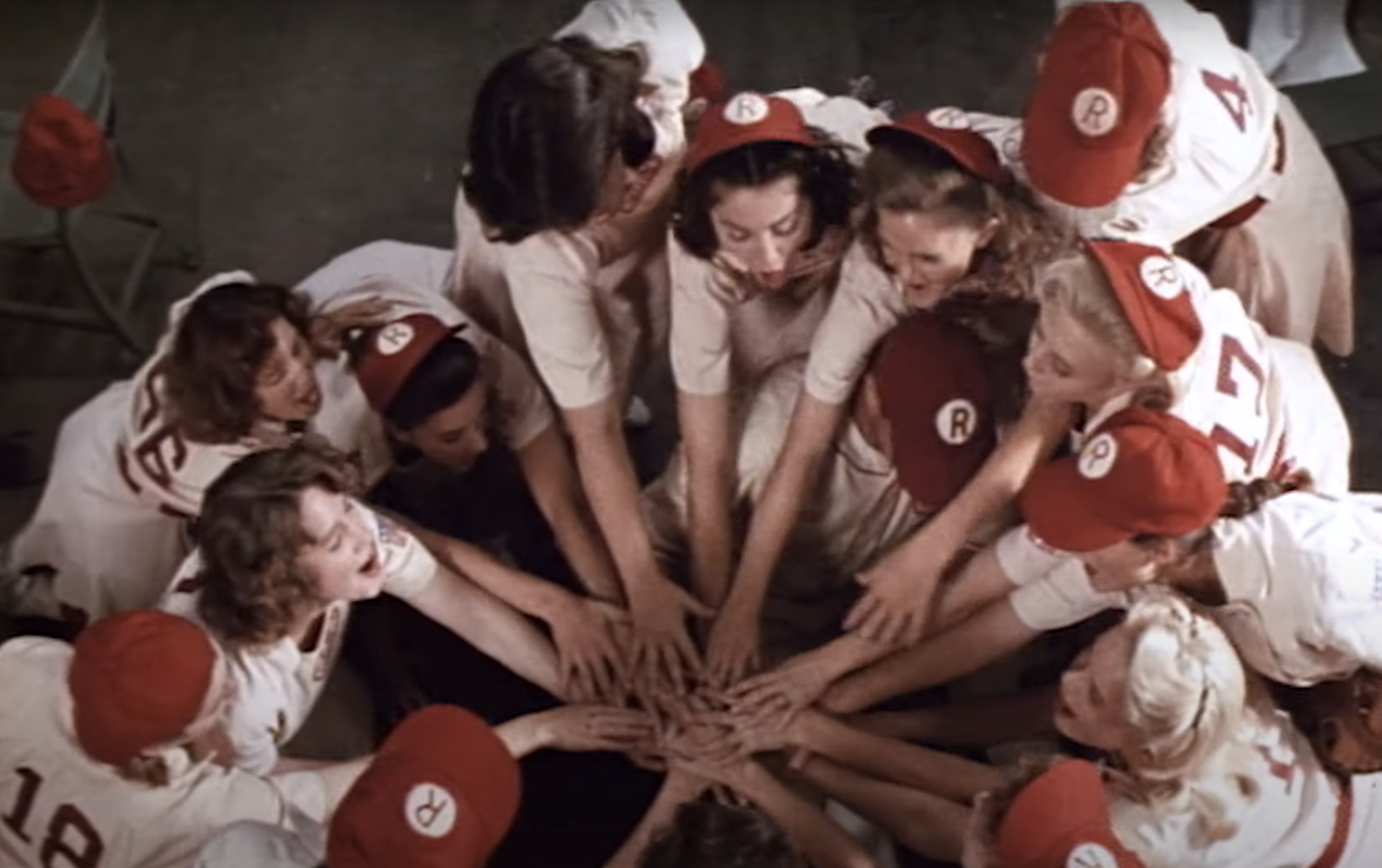 The baseball team, including Madonna, touching hands
