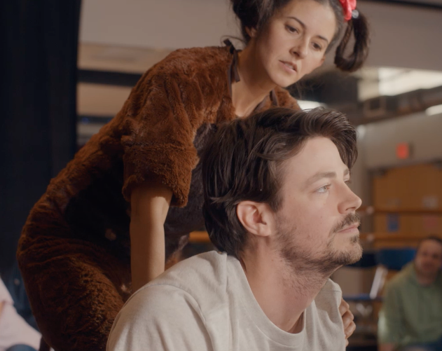 A woman in a dog outfit presses on Max's back