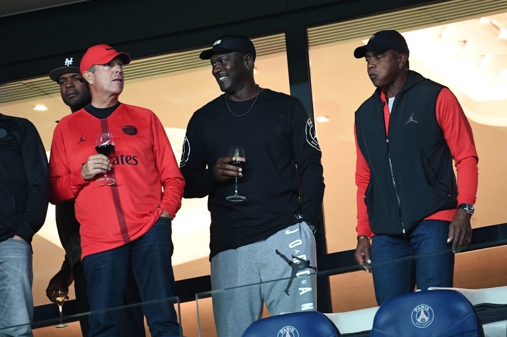 Michael Jordan holding a glass of wine as he attends a soccer match with friends