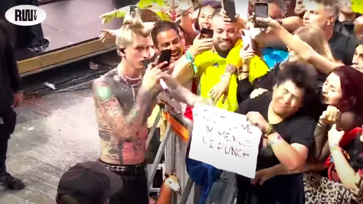 The fan held up a handwritten sign during MGK's performance that read "I just came from Mexico 4 u 2 punch me in the face."