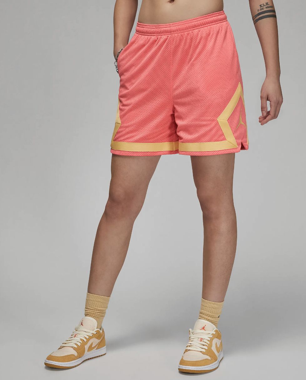 A model wearing the shorts in coral