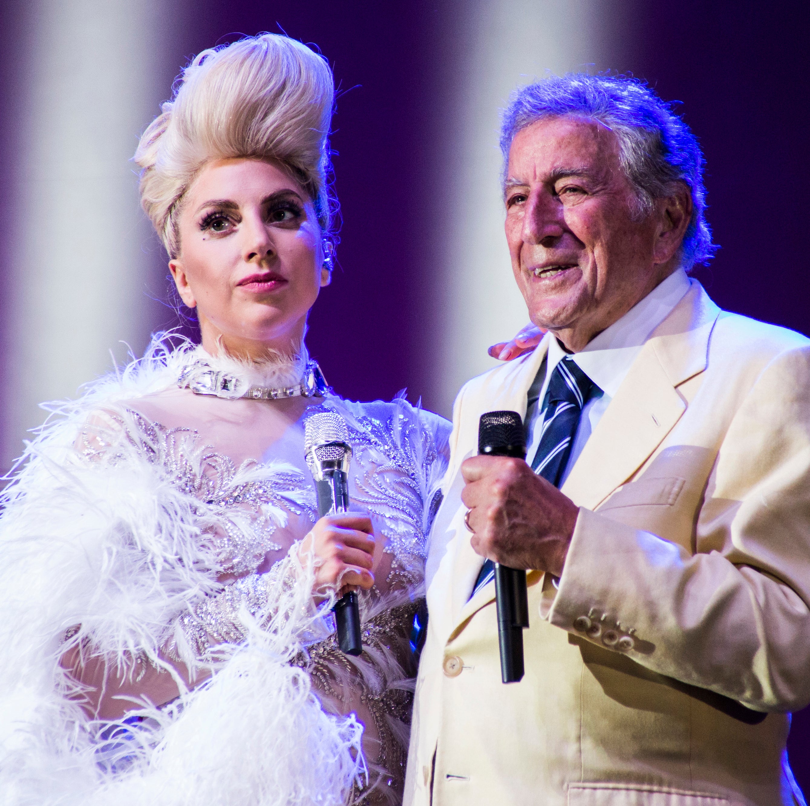 Gaga and Tony onstage holding microphones