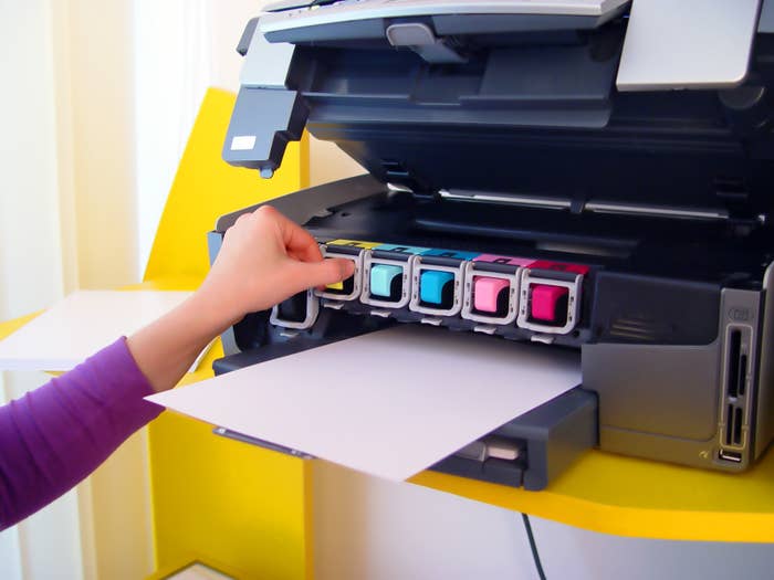 a person changing the printer ink