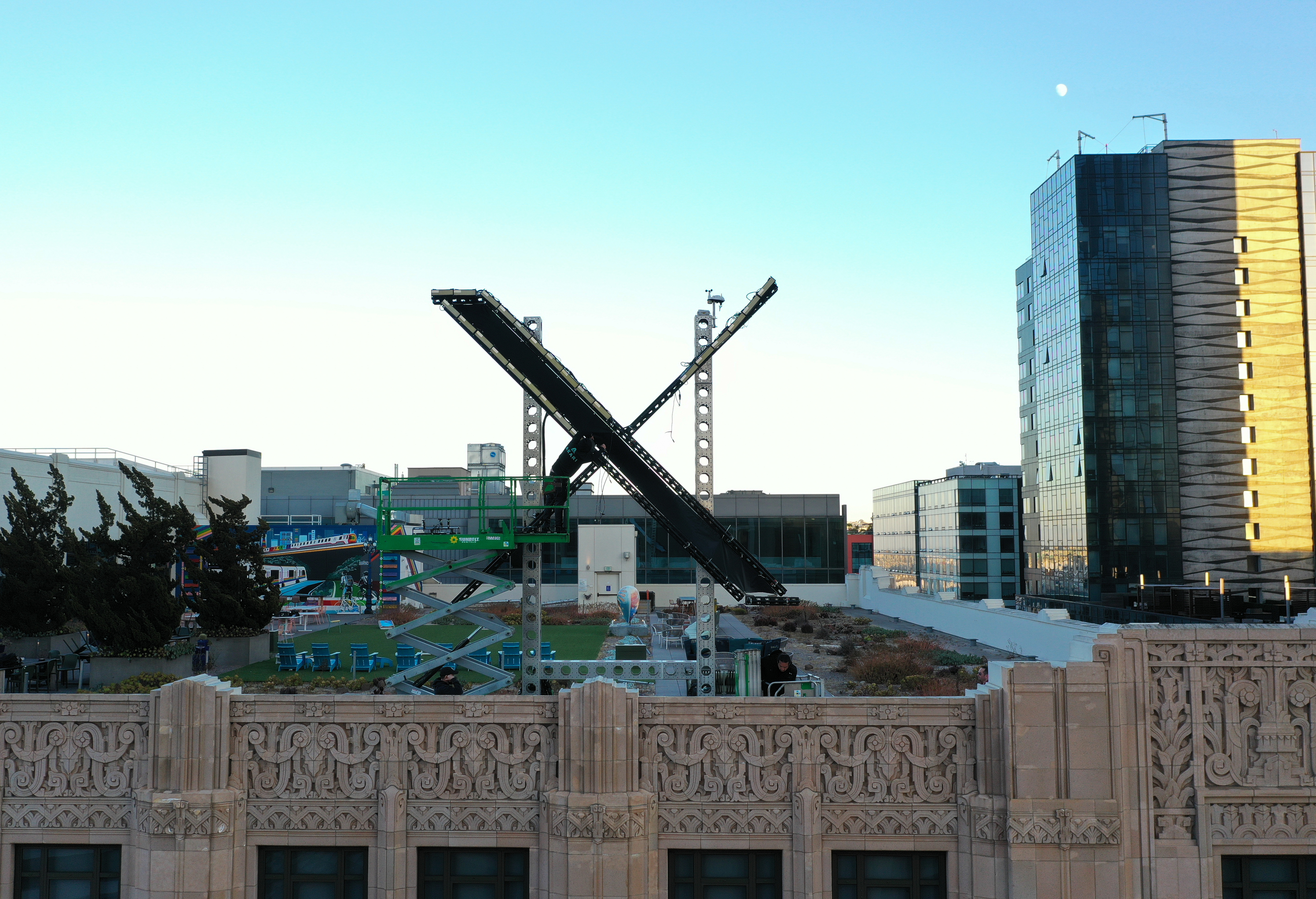 A giant X being erected on top of a building