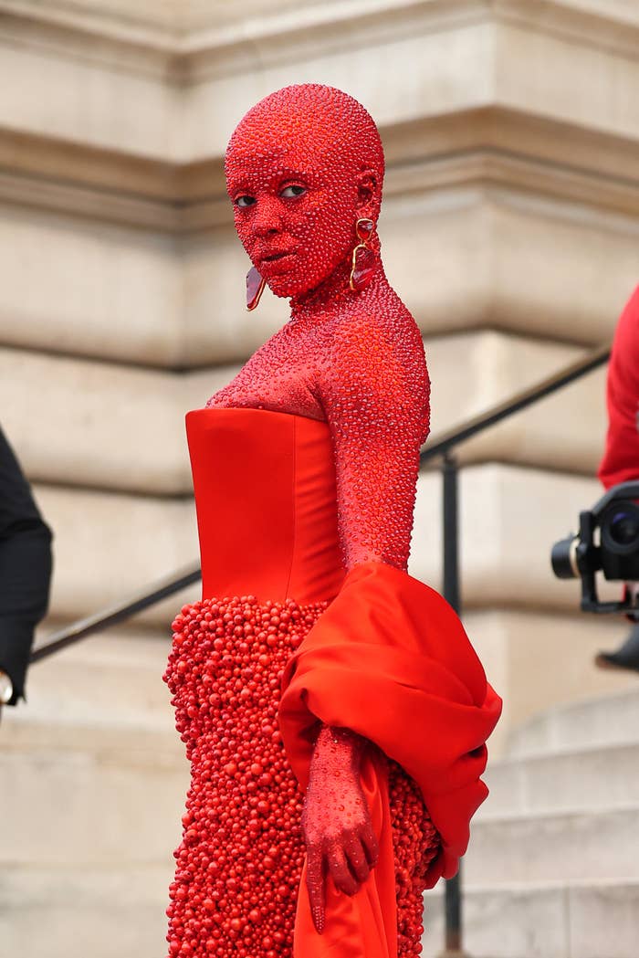 Close-up of Doja at a media event in a red bubbly outfit