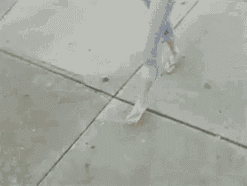 GIF of Taylor Swift drinking coffee and holding books and appearing to be walking into school