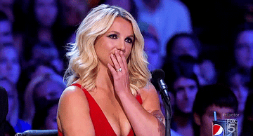 GIF of Britney Spears holding in a laugh